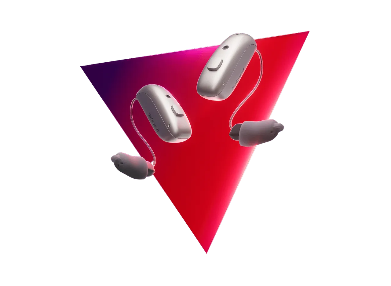 A pair of ReSound Sensia microRIE hearing aids in Sparkling Silver floating over a red and magenta triangle, from ReSound’s campaign