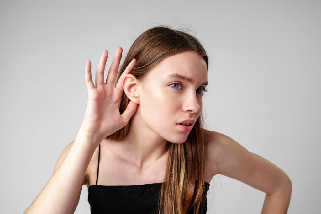 young woman having trouble hearing with her right ear