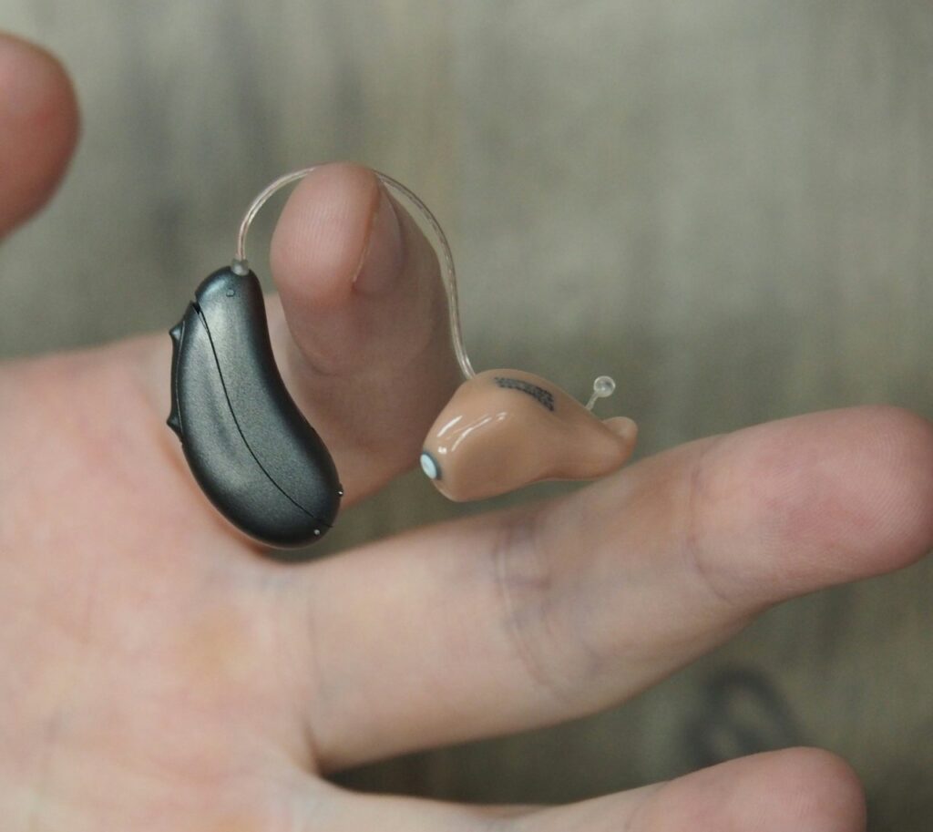 person holding a hearing aid