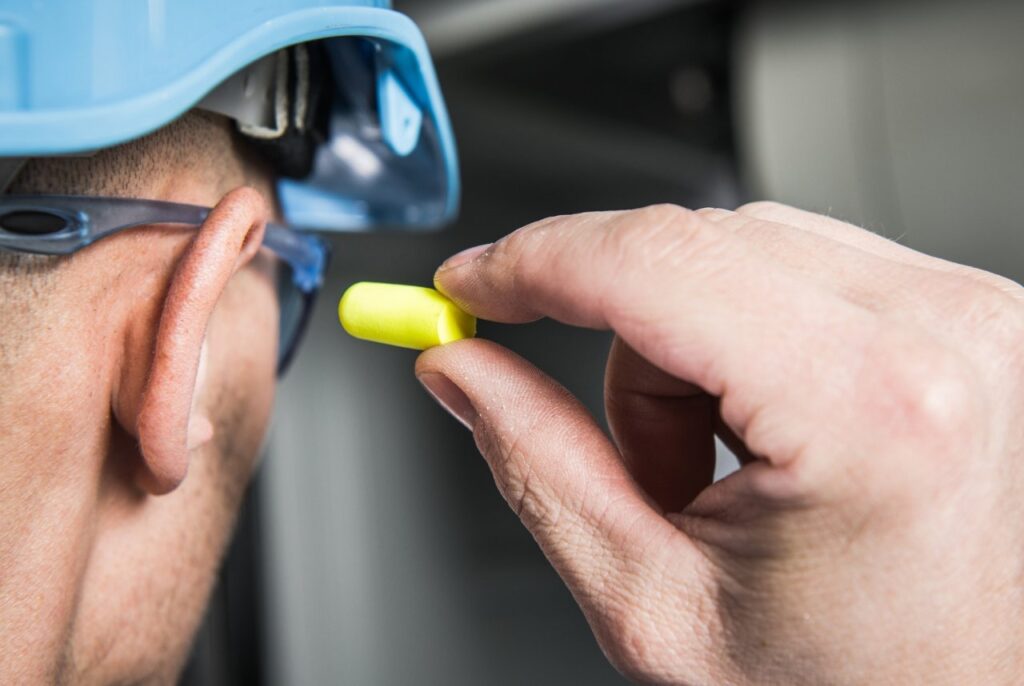 man putting on ear plugs