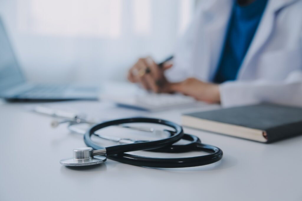 doctor wearing white coat writing on a notebook