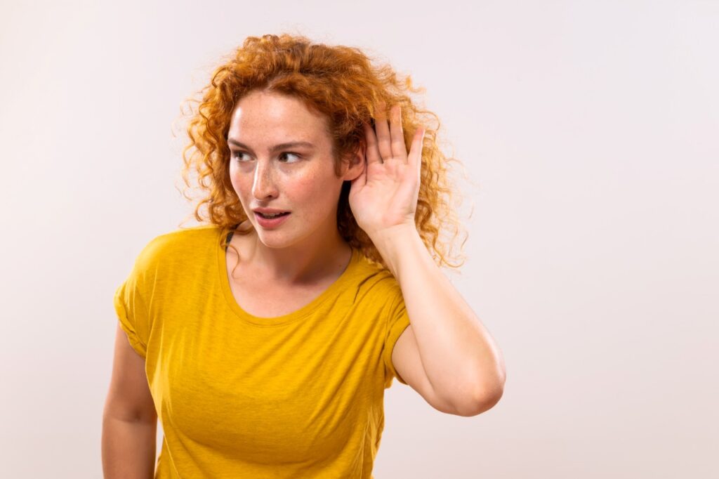 woman with curly hair having trouble with her hearing