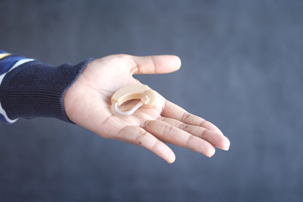 a hearing aid on a person's hand
