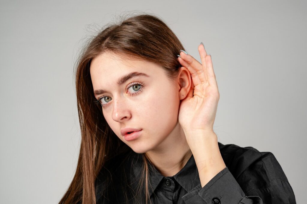 young woman in black shirt having problems with hearing