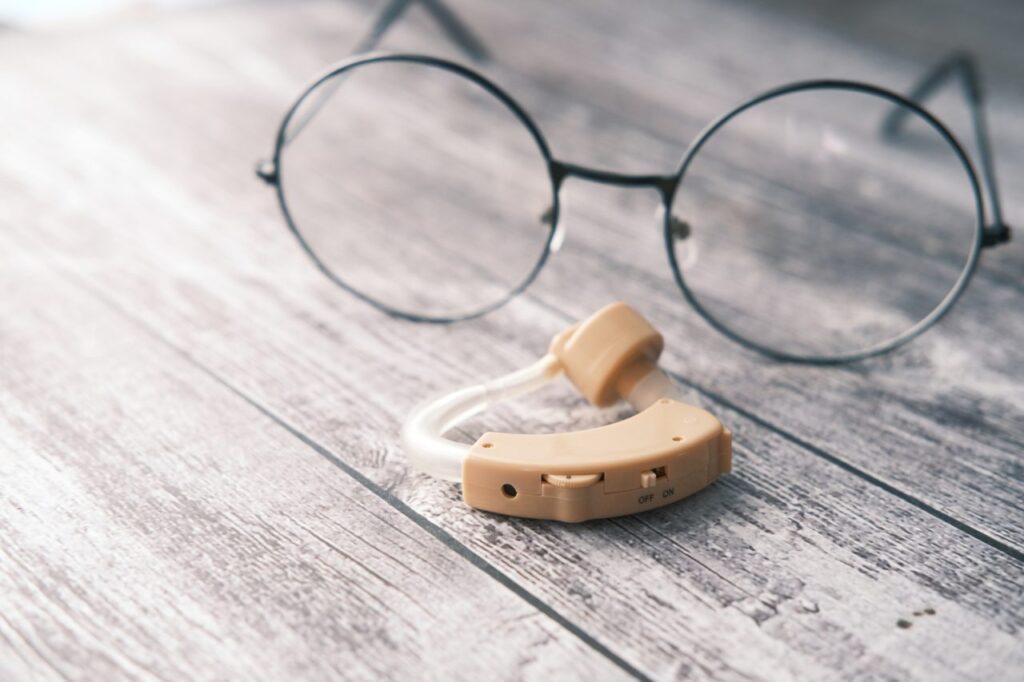 hearing aid and pair of prescription glasses