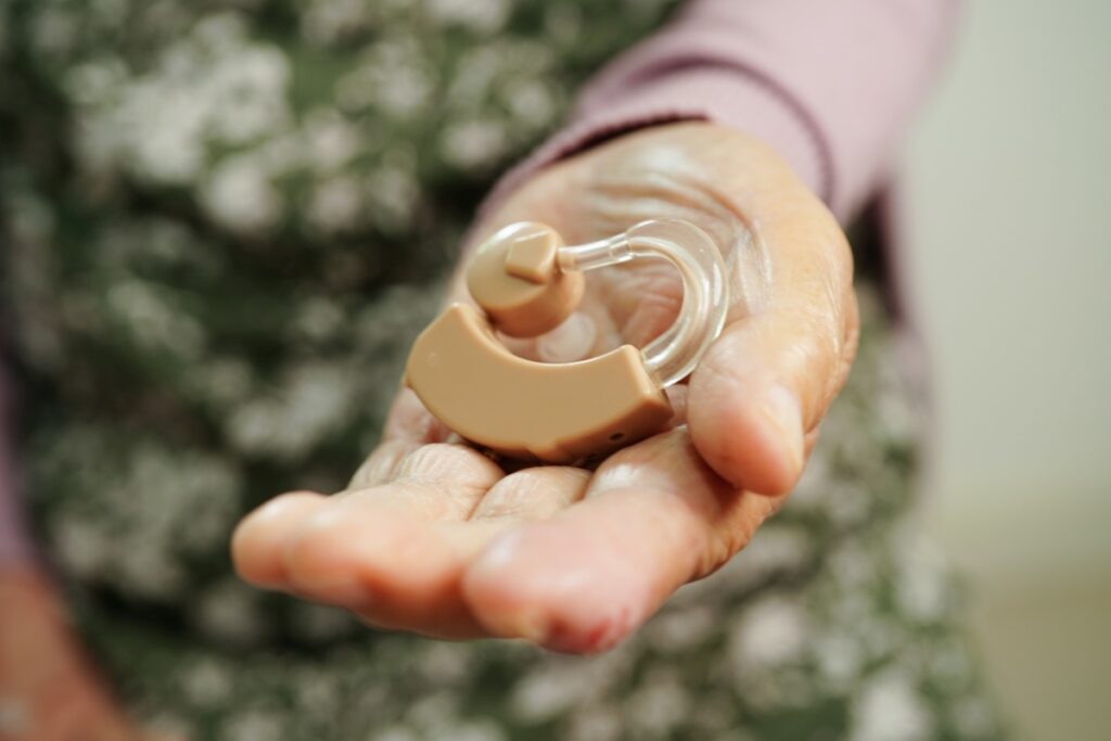 elderly person's hand with hearing aid