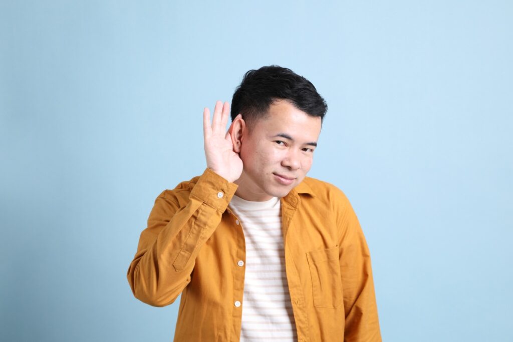 man wearing mustard jacket having a hard time hearing