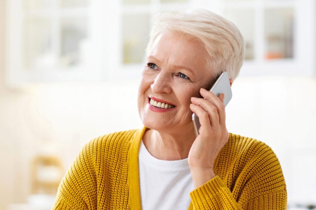elderly woman having healthy lunch and talking on mobile phone