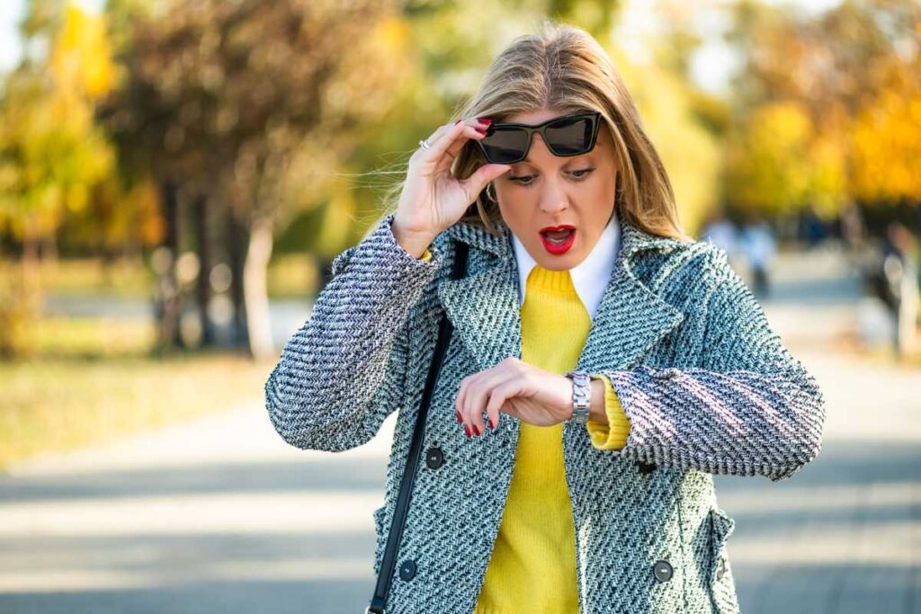 woman with a surprised look on her face while looking at her wrist watch
