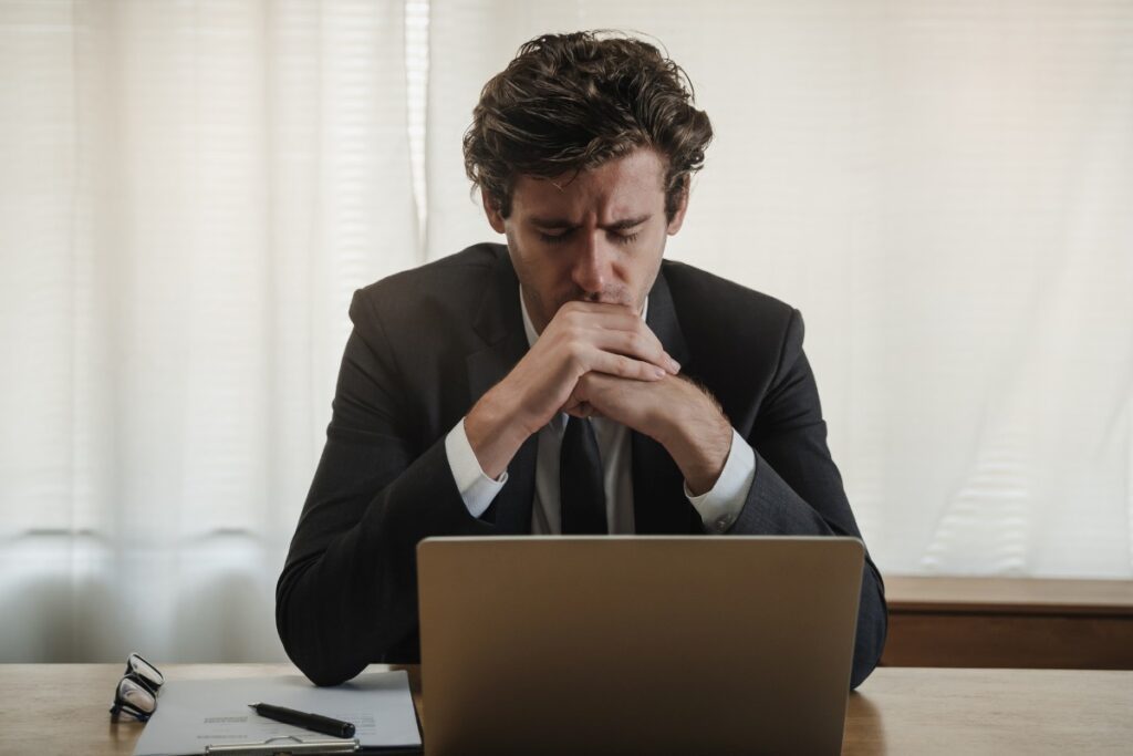 employee exhausted seating in front of his laptop