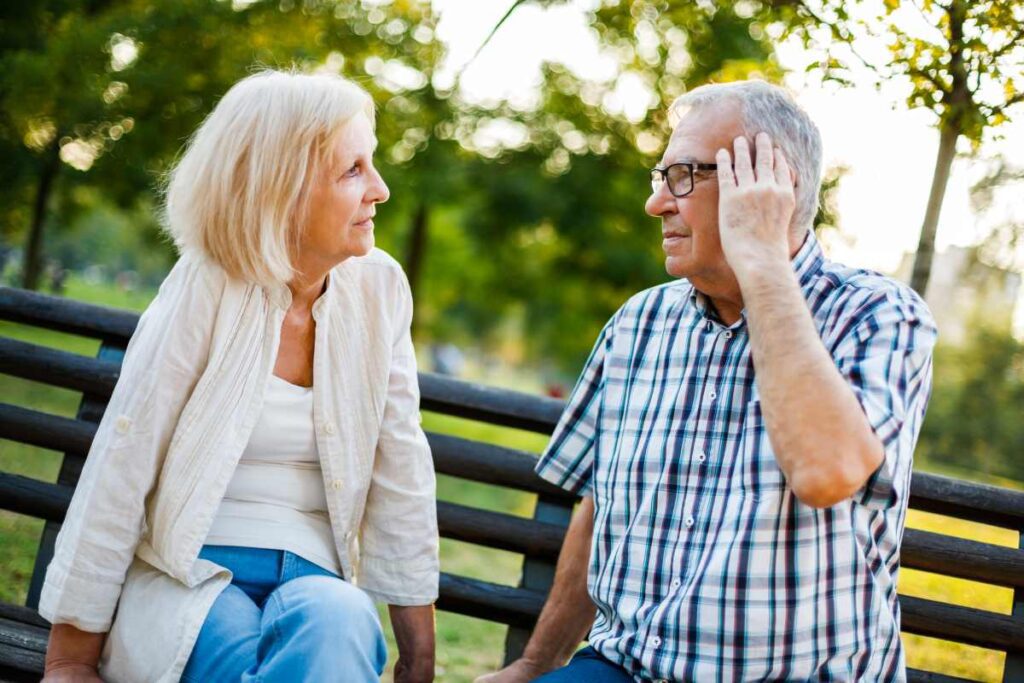 man having hearing problems holds his hand over the ear