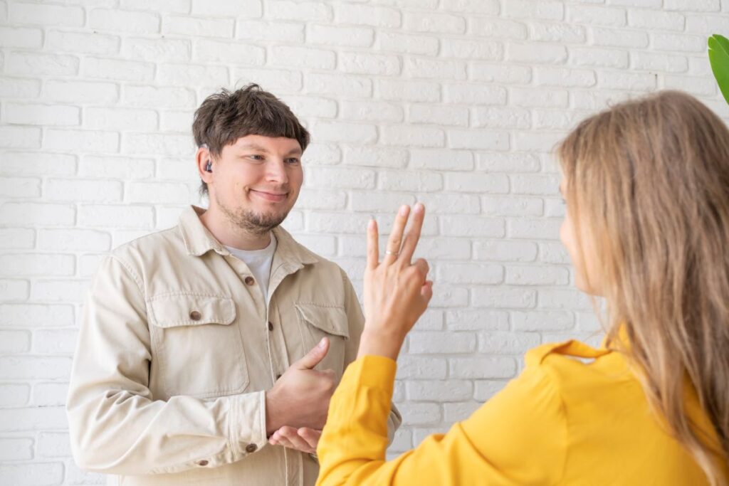 young woman and deaf man with audiology implant, service or help for sound waves